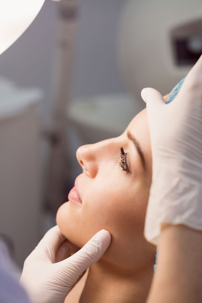 Doctor examining womans face for thread lift procedure